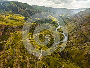 Aerial view dramatic landscape with historical Tmogvi fortress ruins with old wall on hilltop surrounded scenic Mtkvari river and