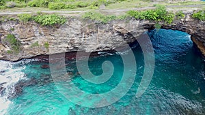 Aerial view by drone 4k camera. Rocky coast with high cliffs, sea surf with breaking waves on the coast, Nusa Penida, Pasih Uug, B