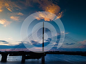 Aerial view from a drone on a cable-stayed bridge on a river in the evening