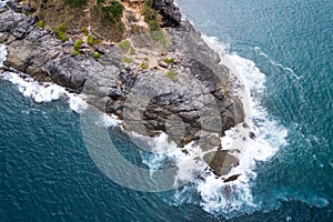 Aerial view Drone camera top down of seashore rocks in a blue ocean Turquoise sea surface Amazing sea waves crashing on rocks