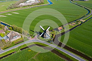 Aerial view from drone on colorful tulip fields, windmills, wind turbines, water canals and agricultural work in