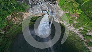 aerial view drone descending and tilt up to Coban Sriti waterfall, Indonesia