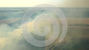 Aerial view from drone farmer Burning dry grass. Fire in a field aerial view. Fire on autumn fields.