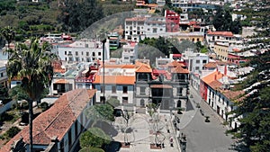 Aerial view - drone flies over a small colorful Spanish city located in the mountains. Colorful houses of ancient