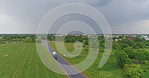 Aerial view of drone follow cars and trucks on wet road after rain is gone.