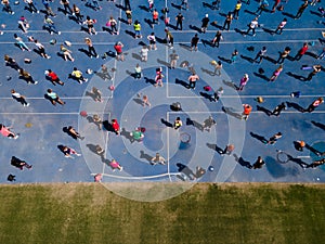 Aerial view from a drone of a group of people doing physical exercise on a jogging track