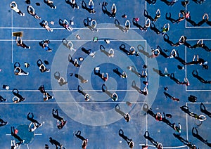 Aerial view from a drone of a group of people doing physical exercise on a jogging track