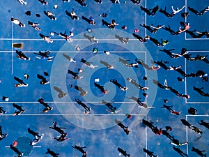 Aerial view from a drone of a group of people doing physical exercise on a jogging track