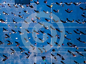 Aerial view from a drone of a group of people doing physical exercise on a jogging track