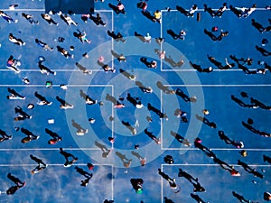 Aerial view from a drone of a group of people doing physical exercise on a jogging track
