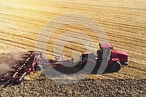 Aerial view drone of harvest field with tractor mows dry grass. Autumn yellow field with a haystack after harvest top view. Harves