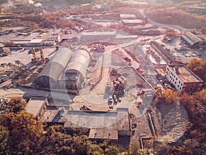 Aerial view from drone of industrial area with warehouses, buildings, trucks, industry equipment, heavy transport