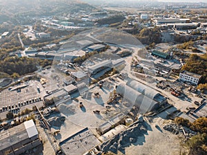 Aerial view from drone of industrial area with warehouses, buildings, trucks, industry equipment, heavy transport