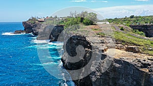 Aerial view by drone overlooking the sea. Rocky coast with high cliffs, Beach with hole on the cliff in Nusa Penida