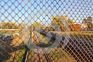 Aerial view from drone on railway road between trees. Landscape background with steel rails. The net is a rabie through which the