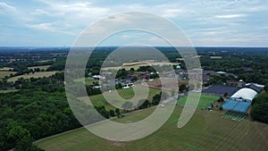 Aerial view of drone rising up over sports fields showing Haileybury school in the background