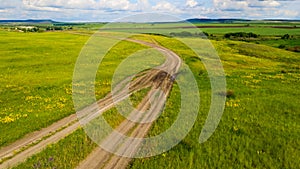 Aerial view from the drone of summer landscape with rural road among the hills