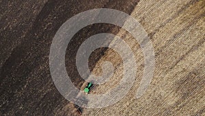 Aerial view, drone view of green tractor with plough working on a field,