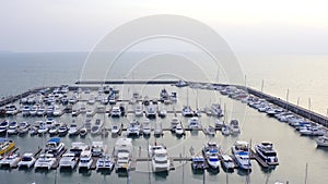 Aerial View by Drone of Yacht Club and Marina. Top view of yacht club. White boats in sea water. Marina dock yachts and