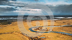 Aerial View Of Dry Meadow And Partly Frozen River Landscape In Sunny Autunn Day. Top View Of Beautiful European Nature