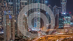 Aerial view on Dubai Marina with big highway intersection night timelapse and skyscrapers around, UAE