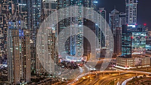 Aerial view on Dubai Marina with big highway intersection night timelapse and skyscrapers around, UAE