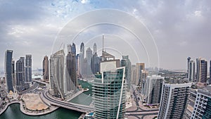 Aerial view of Dubai Marina residential and office skyscrapers with waterfront day to night timelapse