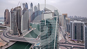 Aerial view of Dubai Marina residential and office skyscrapers with waterfront day to night timelapse