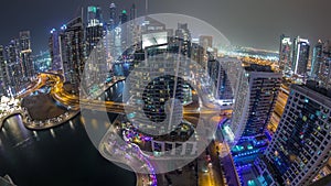 Aerial view of Dubai Marina residential and office skyscrapers with waterfront night timelapse