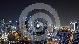 Aerial view of Dubai Marina residential and office skyscrapers with waterfront night timelapse