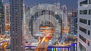 Aerial view on Dubai Marina skyscrapers and the most luxury yacht in harbor day to night , Dubai, United Arab Emirates