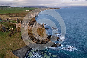 Aerial view with Dunluce Castle, the famous fortress in ruin in Northern Ireland UK, seen at sunrise