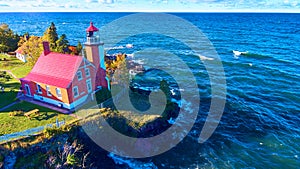 Aerial View of Eagle Harbor Lighthouse on Rocky Coast in Autumn