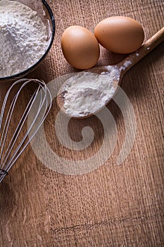 Aerial view eggs flour in spoon bowl corolla