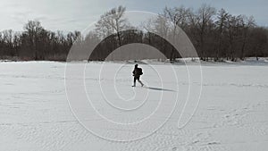 Aerial view an elderly woman engaged in Nordic walking with sticks in the winter forest. Healthy lifestyle concept