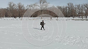 Aerial view an elderly woman engaged in Nordic walking with sticks in the winter forest. Healthy lifestyle concept