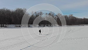 Aerial view an elderly woman engaged in Nordic walking with sticks in the winter forest. Healthy lifestyle concept