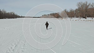 Aerial view an elderly woman engaged in Nordic walking with sticks in the winter forest. Healthy lifestyle concept