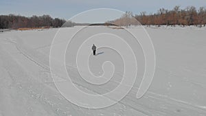 Aerial view an elderly woman engaged in Nordic walking with sticks in the winter forest. Healthy lifestyle concept