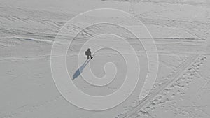 Aerial view an elderly woman engaged in Nordic walking with sticks in the winter forest. Healthy lifestyle concept