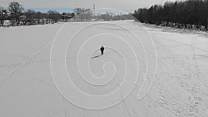 Aerial view an elderly woman engaged in Nordic walking with sticks in the winter forest. Healthy lifestyle concept