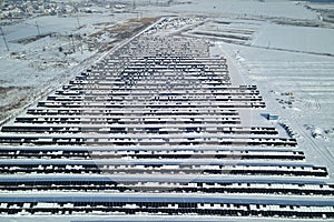 Aerial view of electrical power plant with solar panels covered with snow melting down in winter end for producing clean
