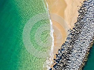 Aerial view of emerald green water and a sandy beach