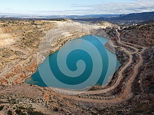 Aerial view on Emerald lake in a flooded quarry. Emerald green lake in flooded opencast mine. Oval lake in mining