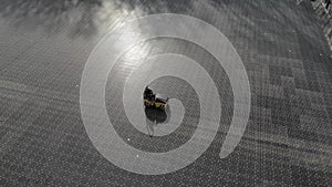 Aerial view employee with the help of a skating rink, compresses the basis for a football field.