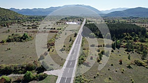 Aerial View Empty Asphalt Road on the Plateau Between Green Fields, Highland Way