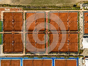 Aerial view of empty clay tennis court on a sunny day