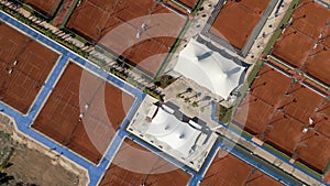Aerial view of empty clay tennis court on a sunny day