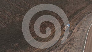 An aerial view of an empty dump truck truck driving along a dirt road. The concept of construction work and the disposal