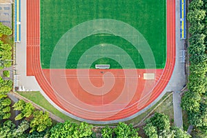 Aerial view of empty green football field with running track